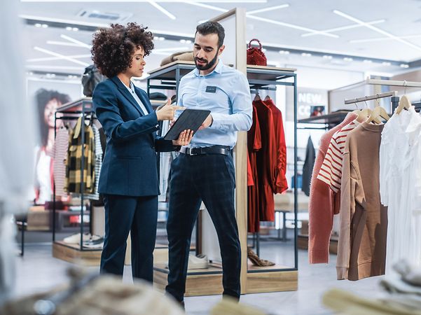 Retail manager discusses strategies with employee – in line with the T Business Mission