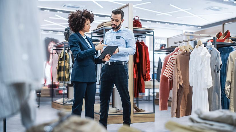 Sales manager of a small fashion shop discusses the mission with a designer on his laptop.