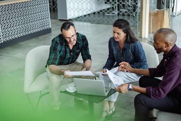 Casual meeting of a smiling, diverse business team analysing financial data