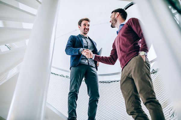 Business partners shake hands on a staircase