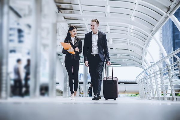 Two business consultants discuss matters at the airport