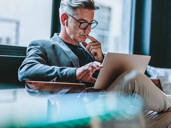 Businessman immersed in digital content on his laptop – expertise and insights from T Business