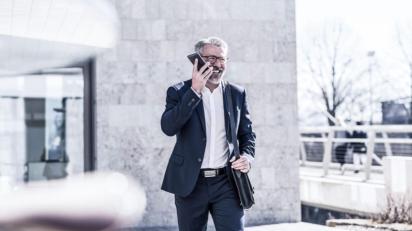 A man is outside talking on the phone.