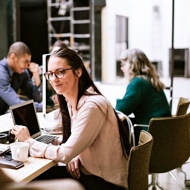 Image shows a group of people working in an open-plan office