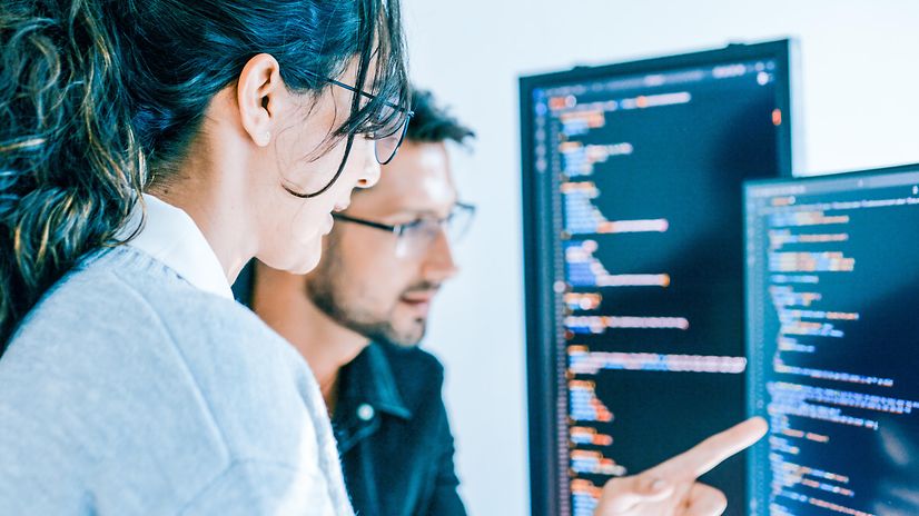 A woman and a man are looking at a screen.