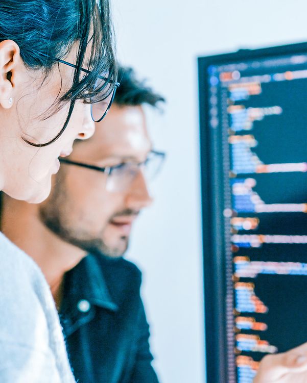 A woman and a man are looking at a screen.