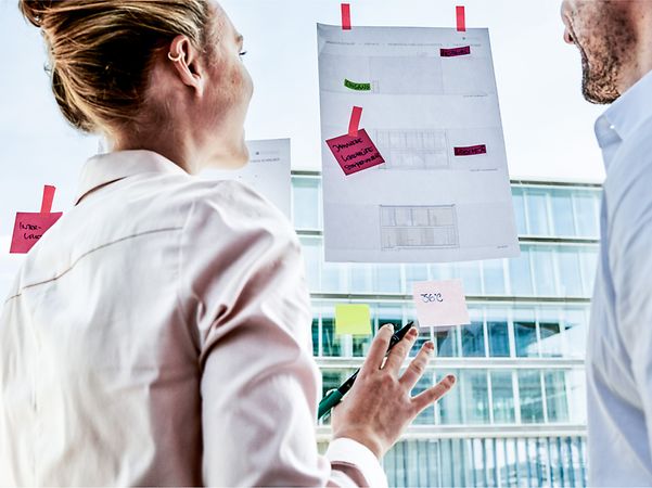 A woman and a man are looking at a sheet of paper.