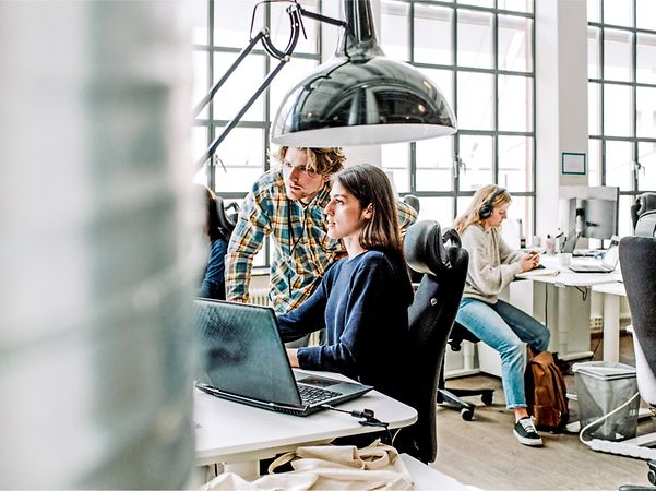 Two people are looking together on a screen.