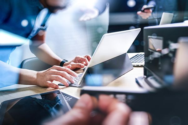A man is sitting in front of his laptop and working.