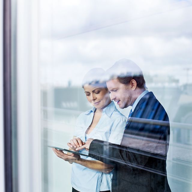A man and a woman learn about secure mobile solutions on a tablet.