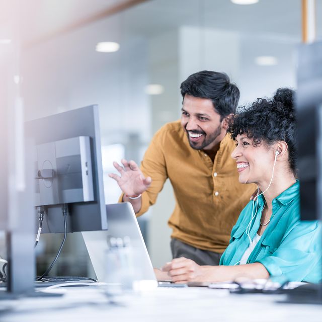 A woman and a man look together at a screen showing Telekom solutions for mobile communication with customers.