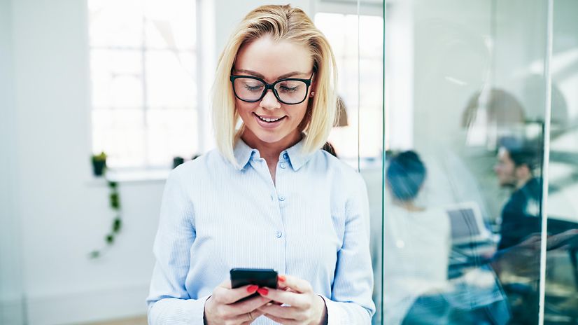 Woman reading a text message on her smartphone and smiling