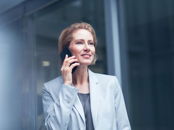 A woman is talking on the phone with a smartphone in her hand.