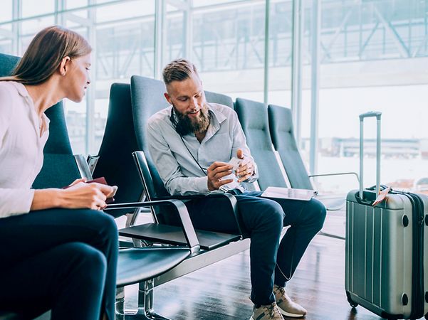 Business people in a waiting room exchange business cards to stay in touch on the subject of Business Voice VPN.
