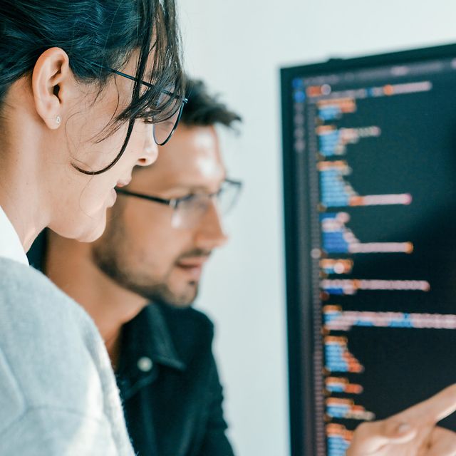 Two colleagues are discussing the matter in front of a screen displaying data on Telekom’s network solutions