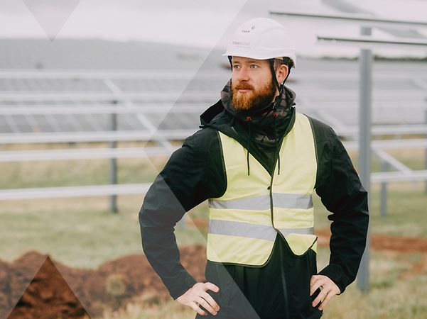 MaxSolar employees in yellow protective clothing with white helmets on a solar field