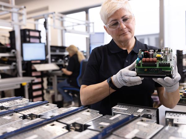 Janitza – Production worker wearing safety goggles and gloves during measuring device testing