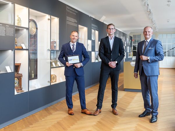 Junghans watches display case and gentlemen in dark suits with SAP tablets