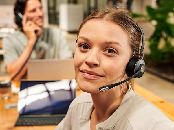Friendly young woman wearing a headset in the Handelsblatt Media Group office