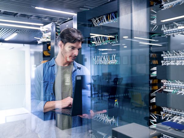 IT specialist repairs a network server at a company headquarters.