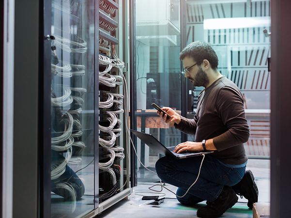 IT technician in the data centre performing server maintenance for managed hosting