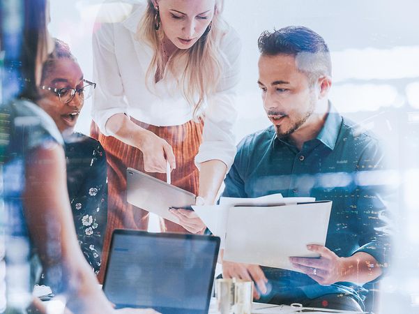 A team in a bright meeting room discusses topics related to the Internet of Things.