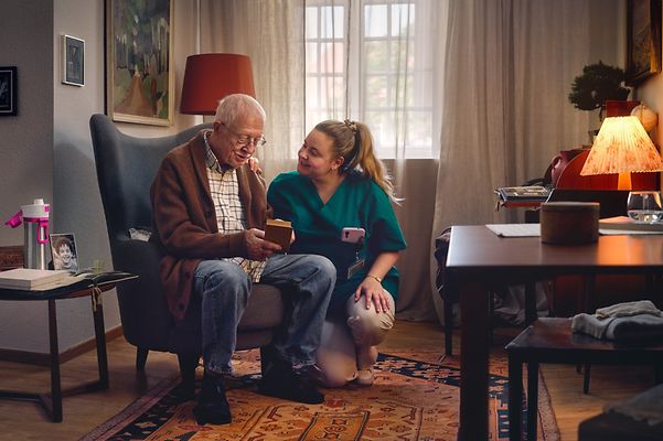 Caregiver looks after elderly gentlemen in a care facility