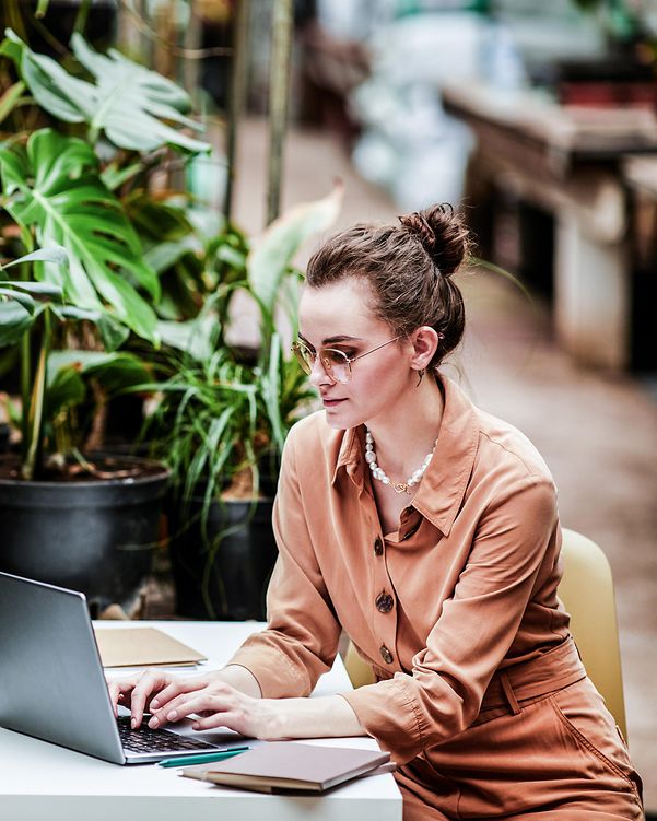 Junge Frau nutzt nachhaltige IT-Lösungen im Büro.