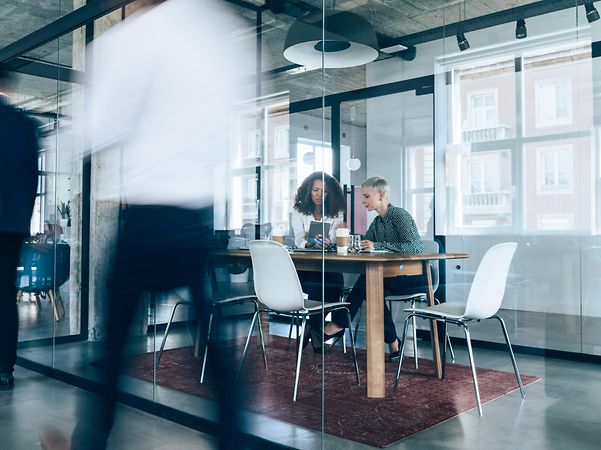 Business professionals collaborating in a modern glass-walled meeting room