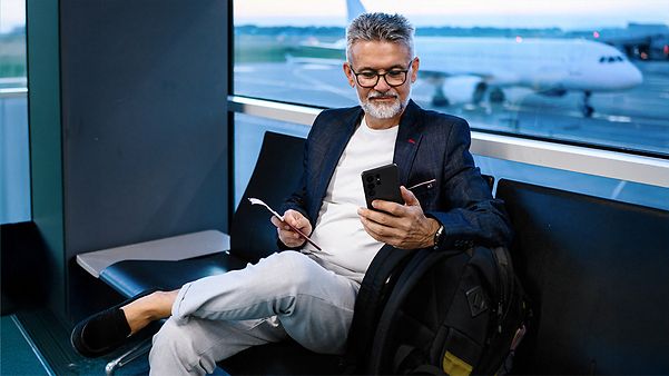 Ein Mann mit Samsung Galaxy S26 in der Hand nutzt die NowNudge Funktion, um Nachrichten zu beantworten.