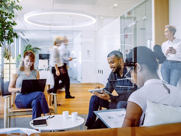 Mehrere Personen arbeiten remote in einem modernen Büro