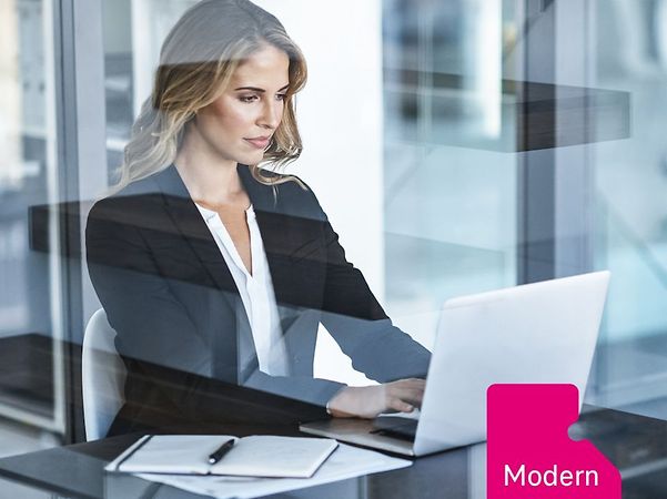 Person im modernen Büro arbeitet am Laptop an einem Schreibtisch hinter Glas, Notizbuch daneben, Schriftzug „Modern Work“.