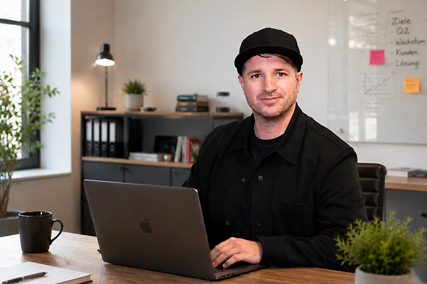 Gründer Andy sitzt am Laptop in seinem Büro