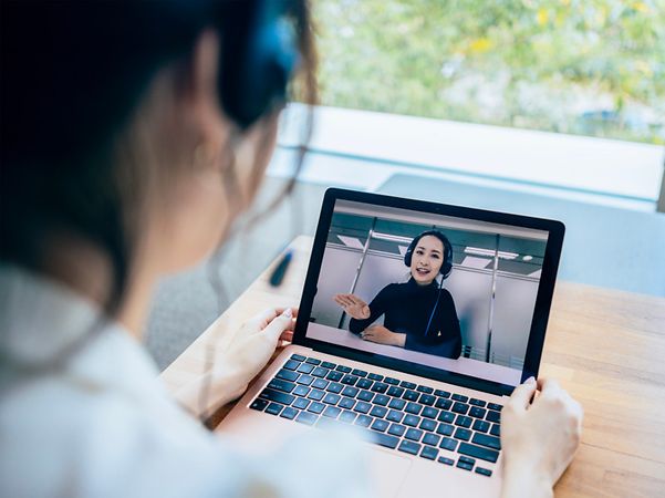 A person is making a video call with a consultant on a laptop.
