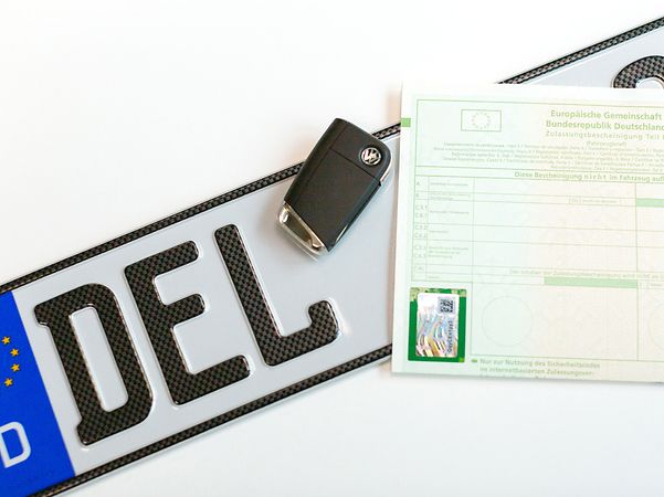 KFZ-Nummernschild mit Fahrzeugschein und Autoschlüssel zur digitalen Zulassung von Tönjes 