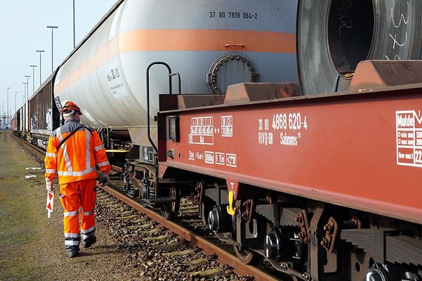 Güterwagen von DB Cargo auf Schienen mit Fachexperte im Schutzanzug