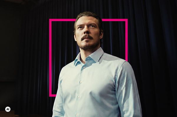 Trust-the-T CEO im blauen Hemd schaut ueberlegt und forsch mit Magenta Grafik