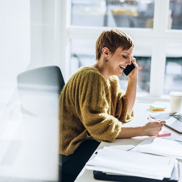 Lächelnde Geschäftsfrau nutzt den Company DSL Tarif mit Doppelflat von T Business.