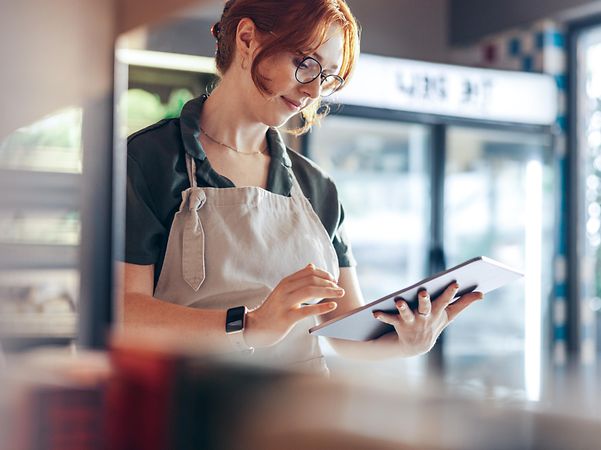 Eine Bäckerin prüft ihren Local Listing Firmeneintrag und ihre Online-Bewertungen am Tablet.