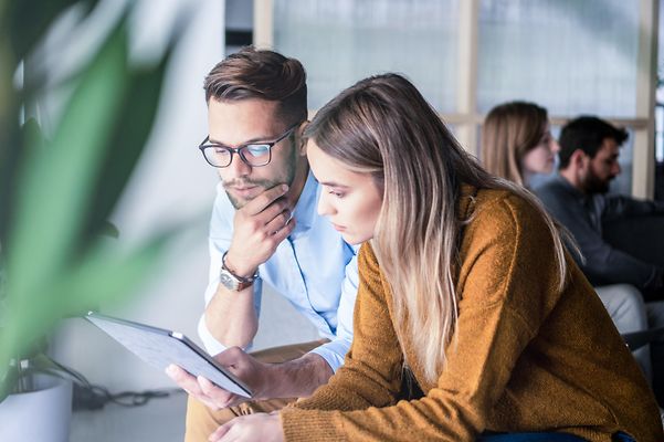 Zwei Kollegen besprechen Fragen mit Hilfe eines Tablets