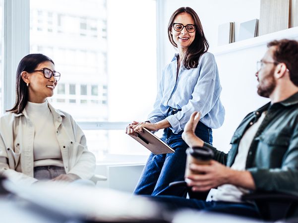 Zwei Frauen und ein Mann sprechen über Device as a Service für mobile Endgeräte im Unternehmen.