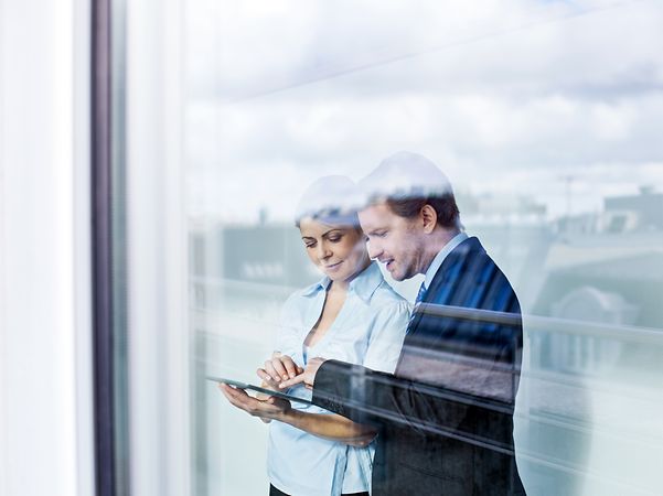 Ein Mann und eine Frau informieren sich auf einem Tablet über sichere mobile Lösungen