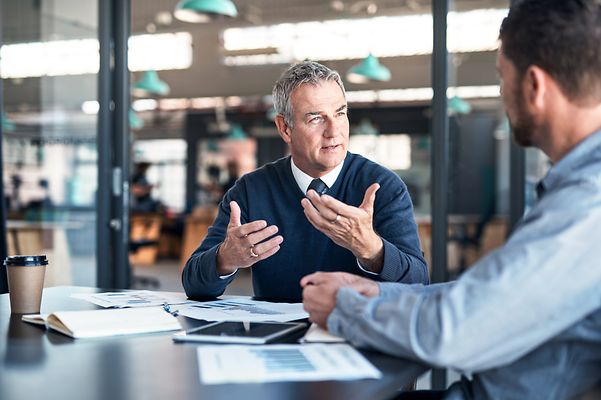 Ein Mann unterhält sich mit einem anderen Mann.