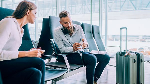 Geschäftsleute in einer Wartehalle tauschen Visitenkarten aus, um zum Thema Business Voice VPN in Kontakt zu bleiben