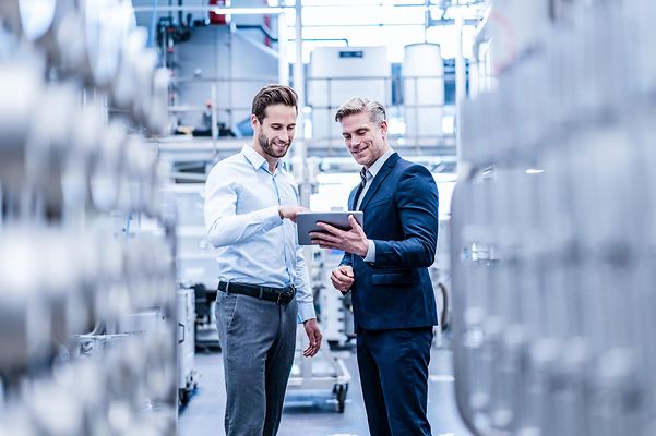 Zwei Kollegen Konfigurieren eine Anlage auf einem Tablet