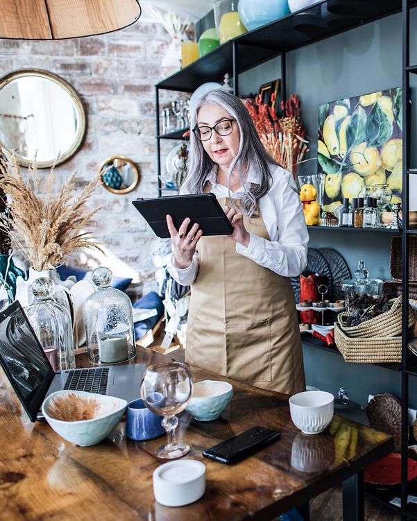 Eine Boutique Besitzerin prüft Ihre Local Listing Premium Firmeneinträge auf ihrem Laptop.
