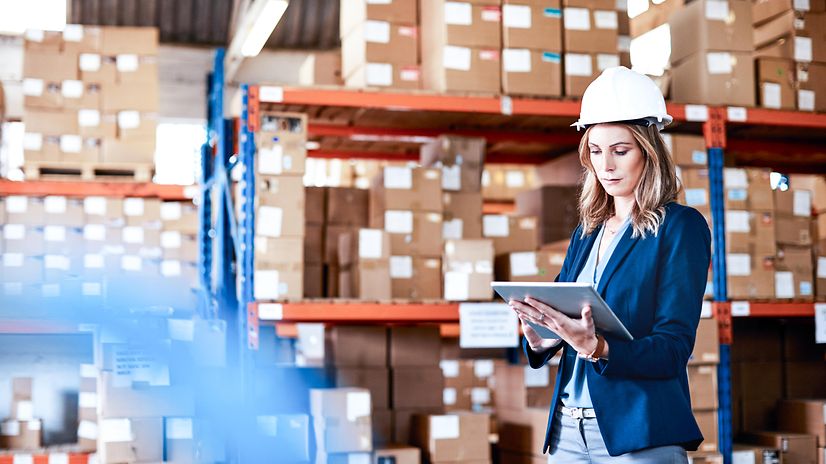 Eine Frau mit Schutzhelm nutzt via Tablet die 5G-Campus Netze zu Datenübertragung auf dem Betriebsgelände