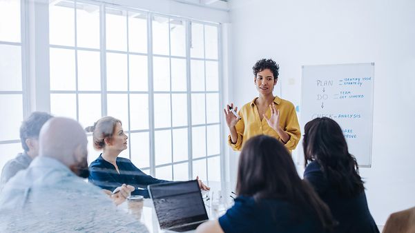 Ein Mann sitzt mit Kopfhörern im Ohr vor seinem Laptop und erklärt die Live Video Production.