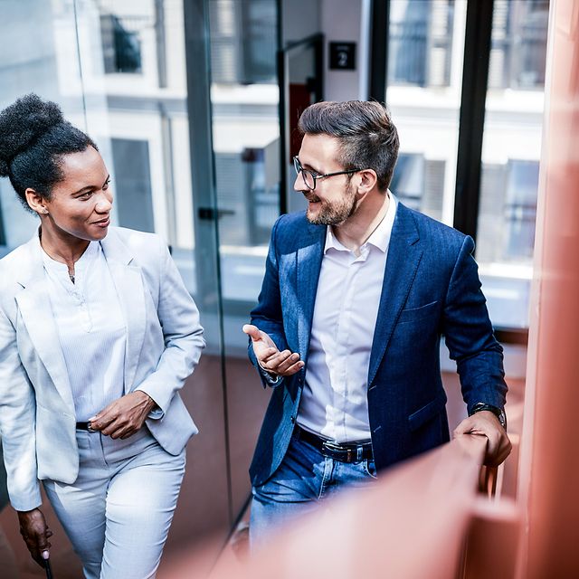 Zwei Personen unterhalten sich auf einer Treppe.