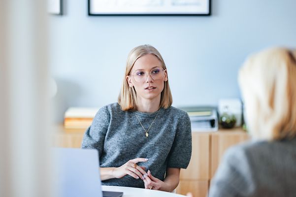 Eine Mitarbeiterin berät eine Kundin zum Thema Zoom X Service